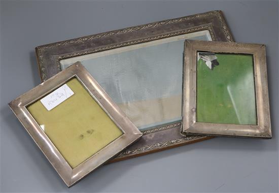 A George V silver mounted rectangular easel mirror and a pair of George V silver mounted photograph frames.